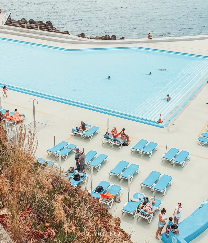 Pool facing the ocean and people sun bathing