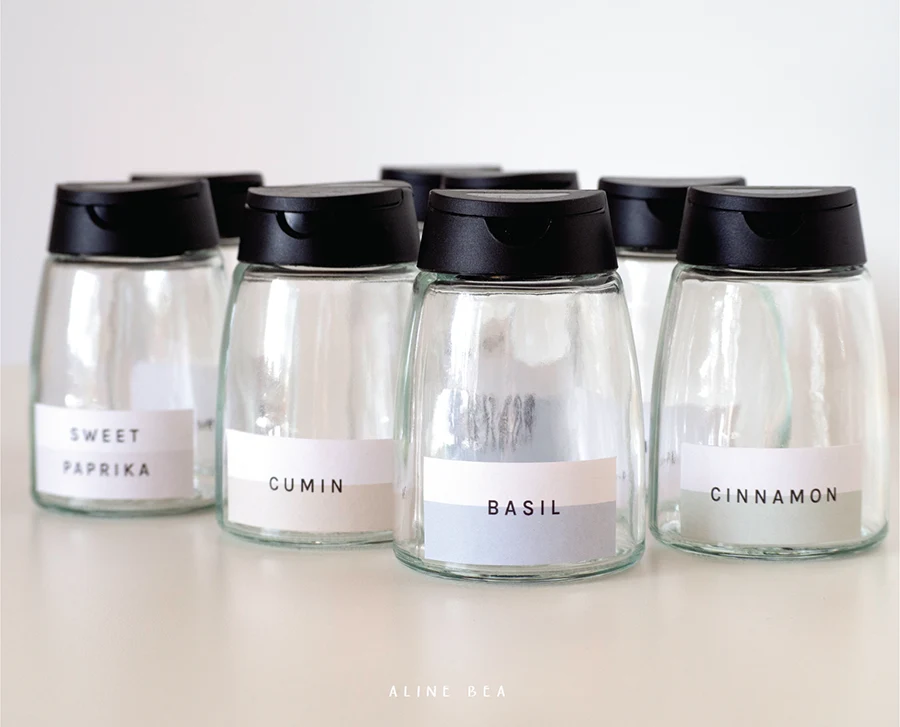 Empty spice jars with labels designed by Aline Bea