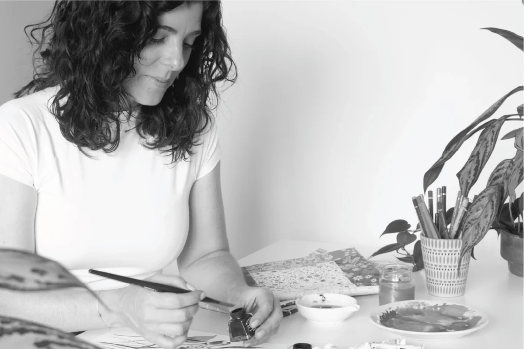 Aline Bea painting with brush and ink on paper