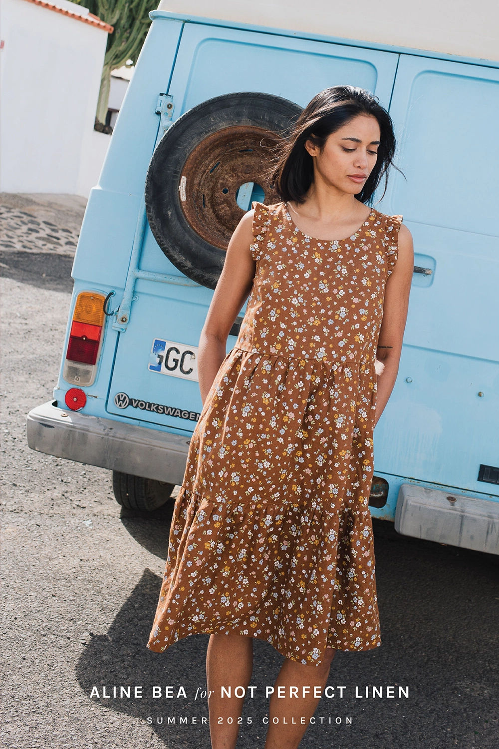 Model-wearing-dress-by-Not-Perfect-Linen-with-Aline-Beas-floraal-pattern-in-front-of-antique-truck-in-summer-sunny-day.