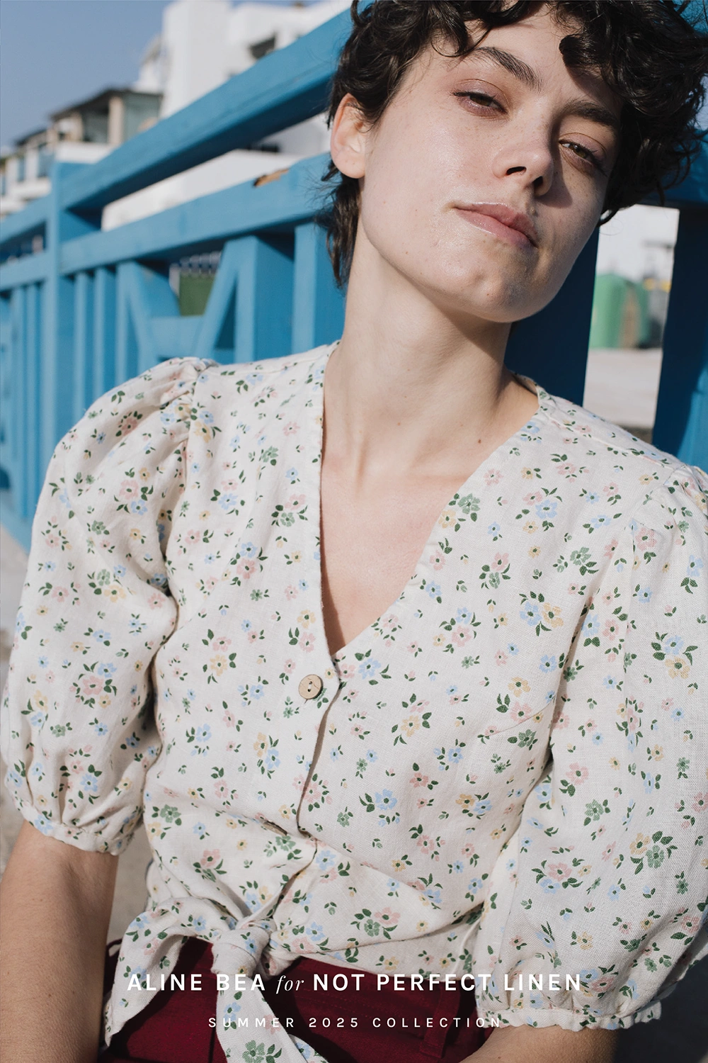 Model-wearing-floral-blouse-by-Not-Perfect-Linen-withh-Aline-Beas-print-design-in-bright-summer-day.