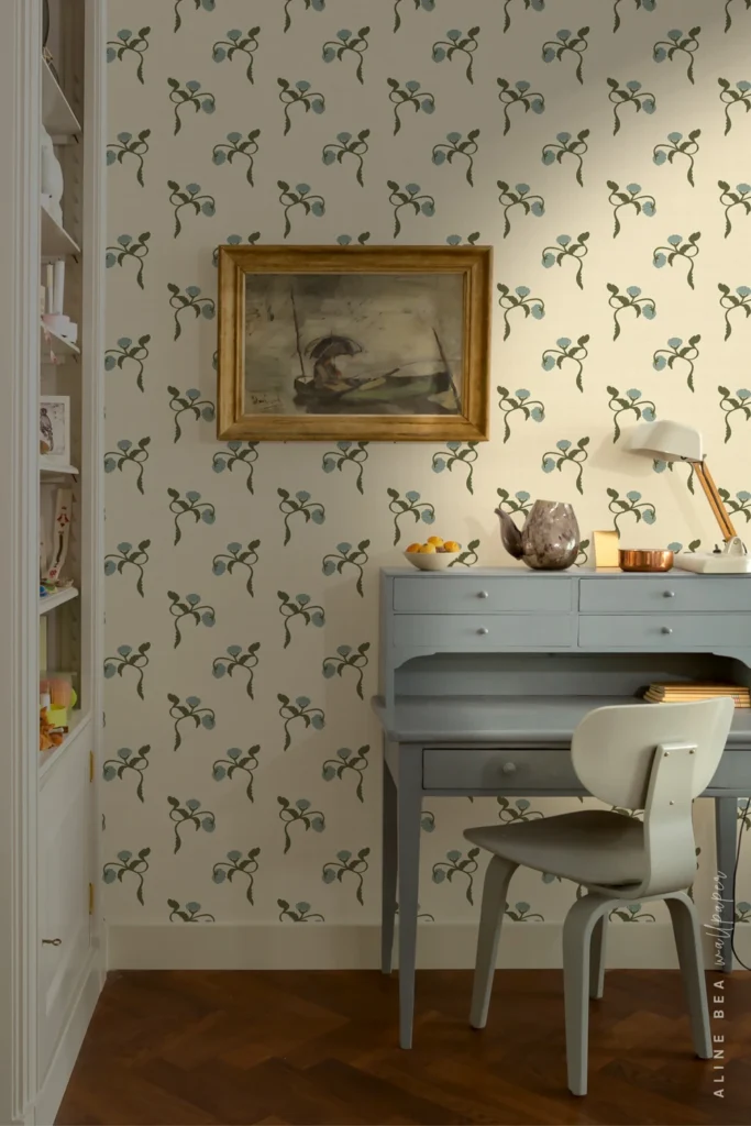 Cream wallpaper with dusty blue floral sprigs and olive green trailing stems in a vintage home office.