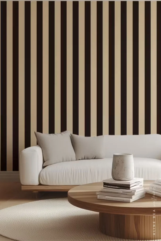 Black and cream vertical stripe wallpaper behind a white sofa in a contemporary living room