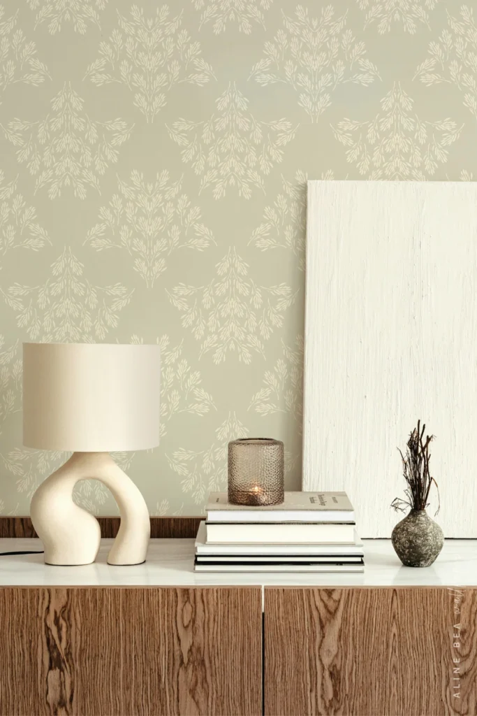 Sage green wallpaper with small cream botanical sprig motifs behind a wooden credenza