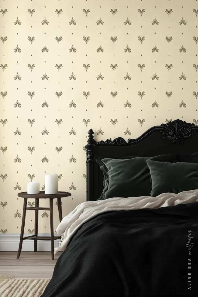 Cream wallpaper with a small black fleur motif behind an ornate black bed frame