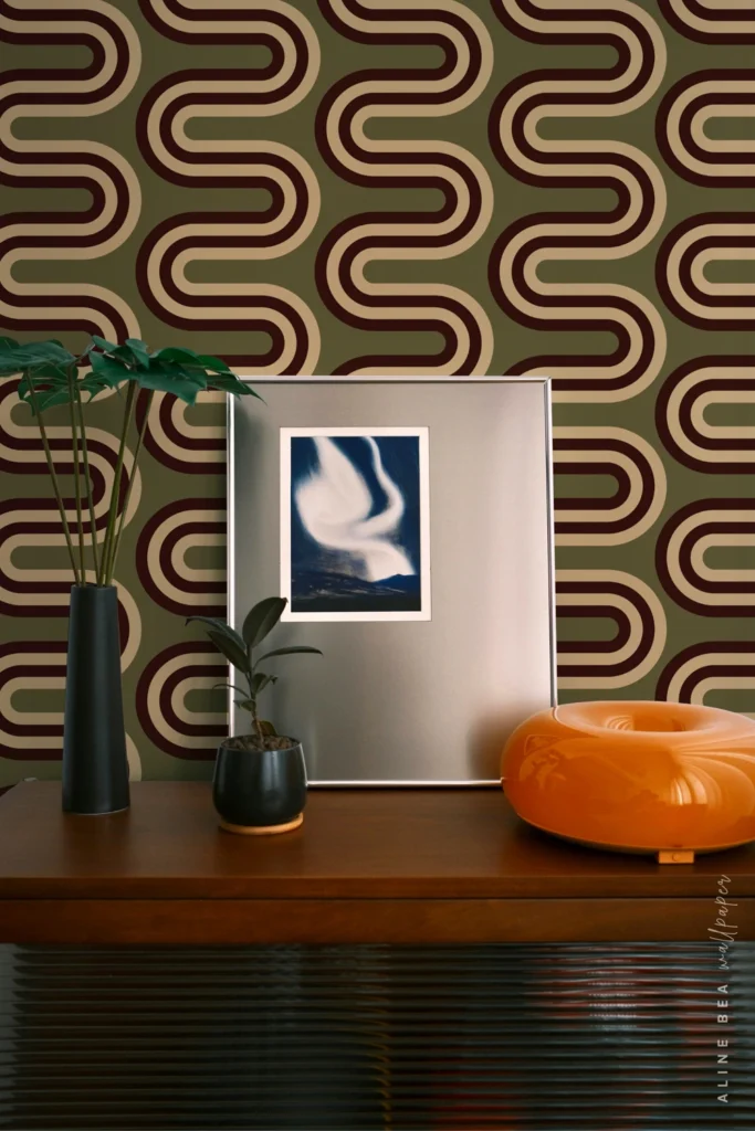 Olive green and maroon wavy ribbon-stripe wallpaper behind a wooden sideboard
