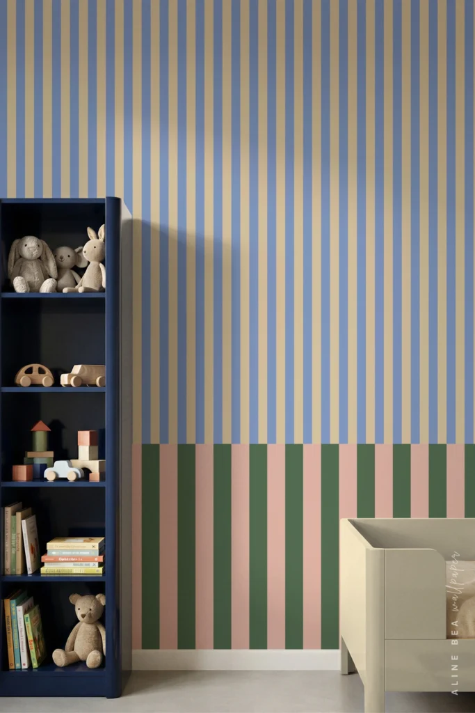 Blue and tan striped wallpaper with a green and pink border behind a nursery bookshelf