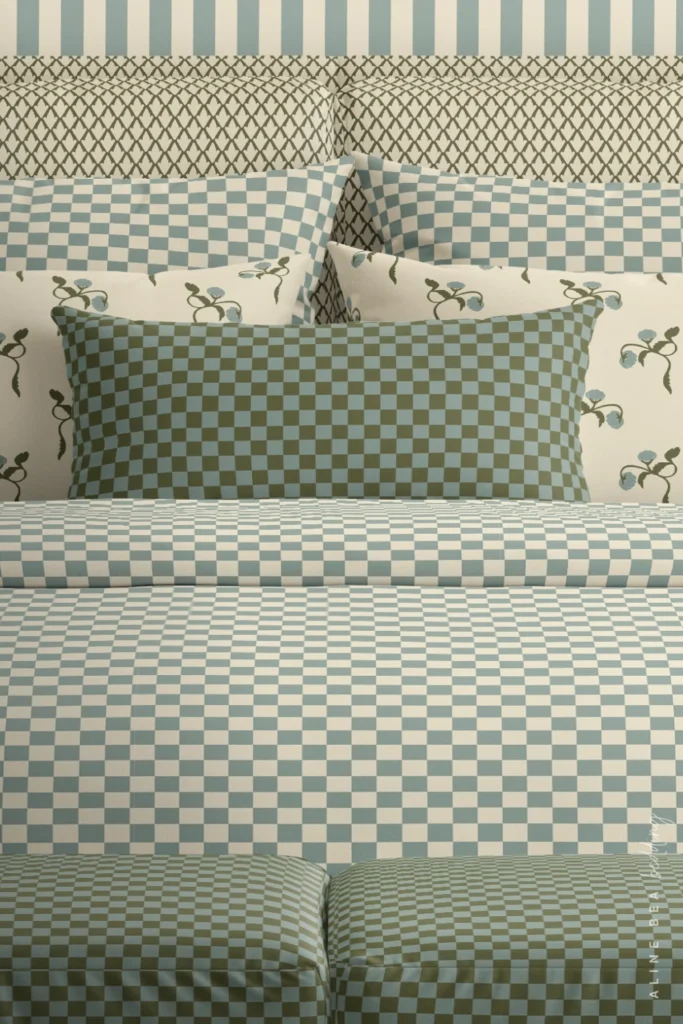 Bedding set in a sage green and dusty blue checkerboard pattern by Aline Bea, with floral and trellis print pillow covers available as home decor at Spoonflower.